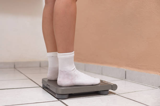Female feet on a weighing scale. Body weight control concept.