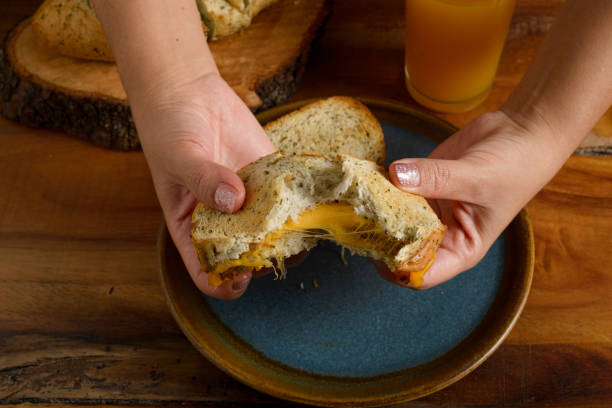 istock Female hands cutting a grilled cheese sandwich. 2193174883