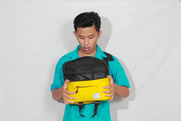 istock Asian man shocked looking at bag contents isolated on white background 2193176654