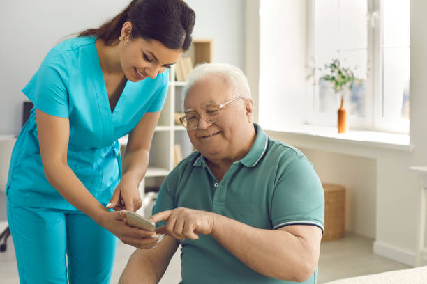 istock Friendly doctor teaching senior man to use special health indicator mobile app 2193176742