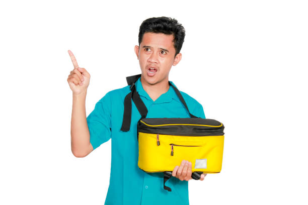 istock Asian man holding camera sling bag pointing to right isolated on white background 2193176770