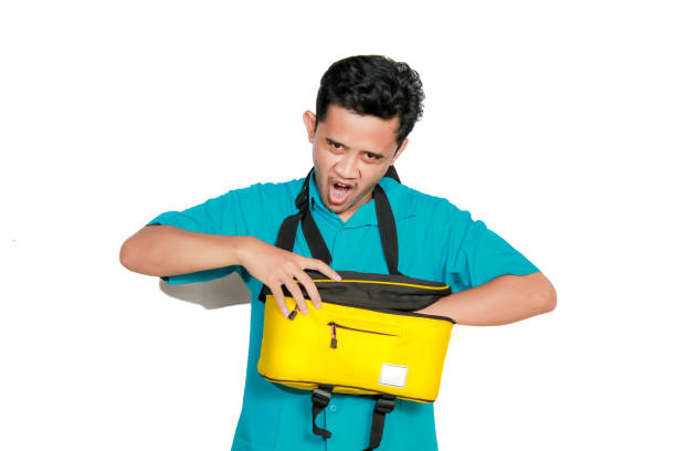 istock Asian man reaching into bag with annoyed expression isolated on white background 2193176772