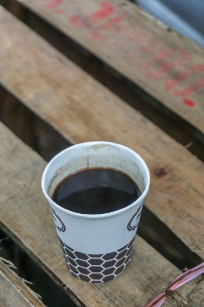 a cup of black coffee on used shipping container wood for the table