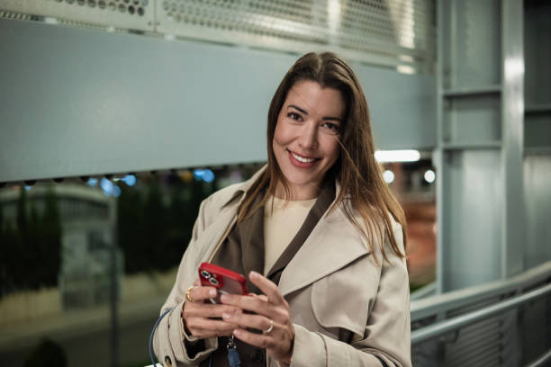 istock Smiling businesswoman using smartphone in modern urban environment 2193178648