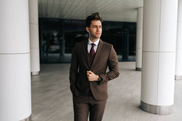 istock Portrait of confident successful businessman adjusting jacket while walking in modern office building, conveying sense of purpose and determination. 2193179648