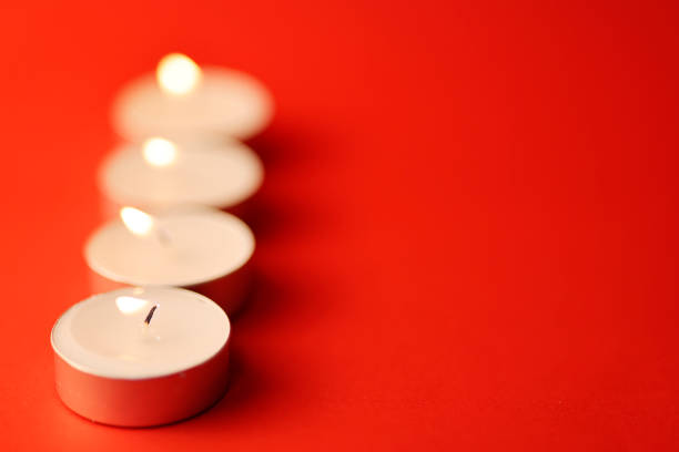 A row of candles on a red background with space for text.
