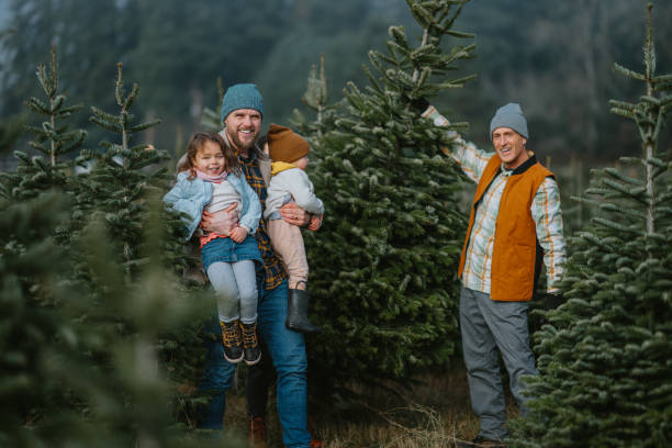 istock Happy multi-generation family posing with Christmas tree at you-cut tree farm 2193180125
