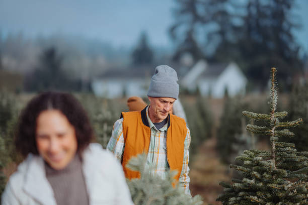 istock Active senior man at Christmas tree farm with his family 2193180130