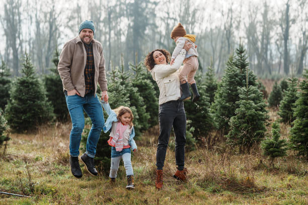 istock Happy family jumping with excitement while at a Christmas tree farm 2193180144