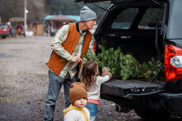 istock Senior man placing Christmas tree in pickup truck bed 2193180192