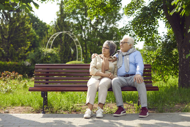 istock Happy mature couple sit on bench in park relaxing 2193183327