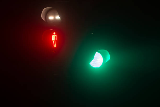 Red traffic lights on a metal pole with a clear blue sky in the background