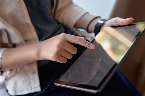 istock Close Up of Childs Hand Tapping Screen of Tablet 2193187478