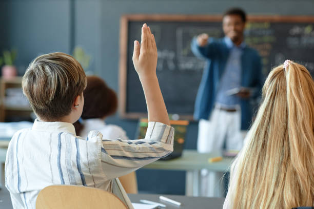 istock Back View of Boy Raising Hin School Class Answering Teachers Questions 2193187481