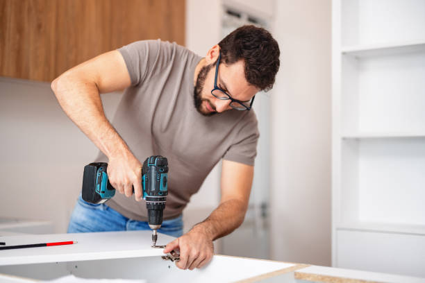 Carpenter Fitting New Kitchen Cabinet in Modern Apartment