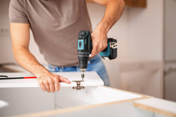 istock Carpenter Using Power Drill to Fit Kitchen Cabinet in New Apartment 2193187685