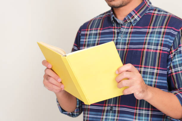 istock A man reading a book with blank yellow cover 2193187791