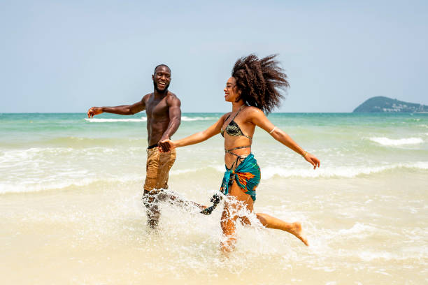 Joyful Couple Running Along the Beach on a Sunny Day