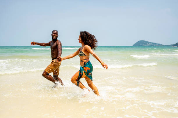istock Happy Couple Running Along the Beach on a Sunny Day 2193188766