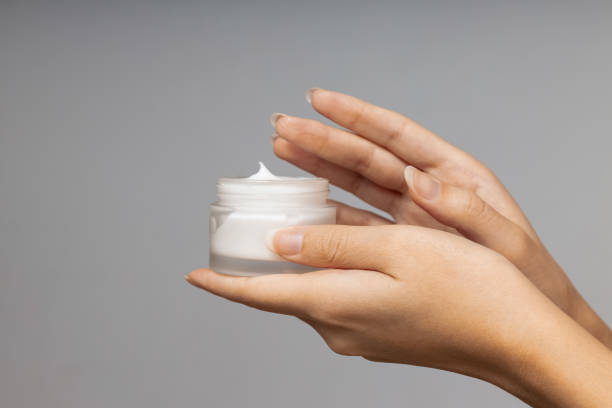 istock Female hands holding jar of cosmetic on light gray background 2193189082