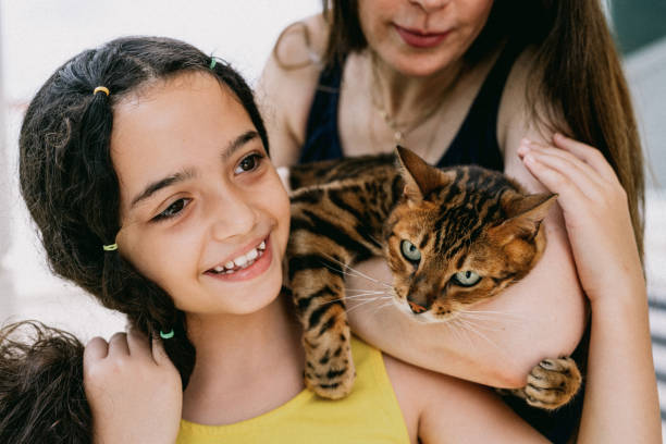 istock Mother and daughter hugging with cat 2193190967