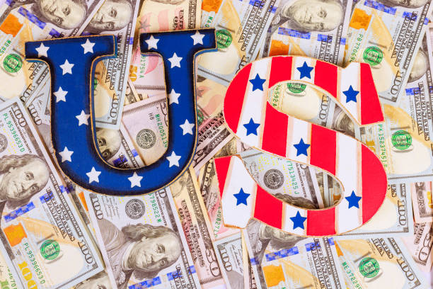 istock Bold letters representing US currency on a background of hundred-dollar bills during economic discussions 2193191800