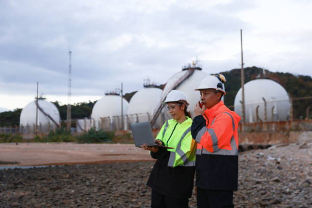 istock Blue-collar workers work at the oil storage field industrial site. Engineering and industrial concept. 2193192524