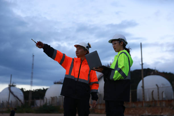 istock Blue-collar workers work at the oil storage field industrial site. Engineering and industrial concept. 2193192527
