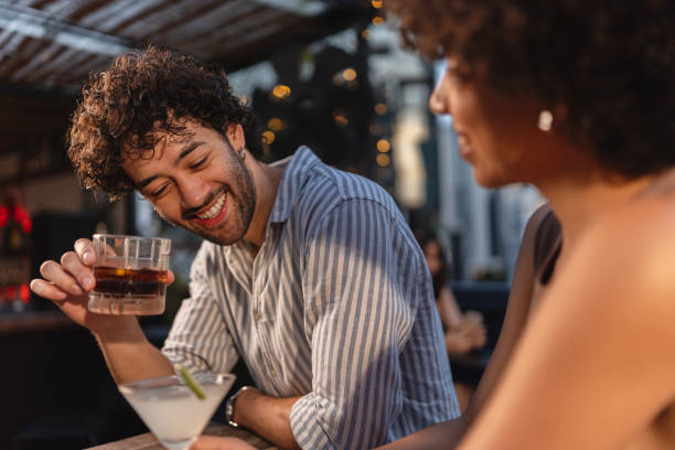 istock Young couple enjoying drinks at a rooftop bar 2193196931