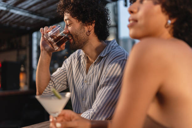 istock Young couple enjoying drinks at a rooftop bar 2193196934