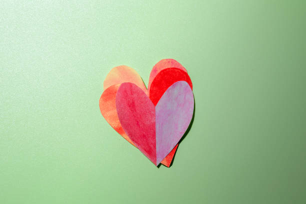 The pile of red hearts on a colored background. Copy space. Mockup. Valentine Card. Decoration for Valentine celebration