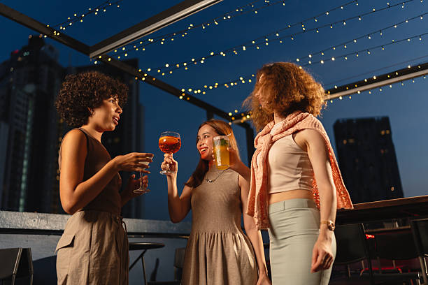 istock Women chatting with drinks at a rooftop bar 2193198075