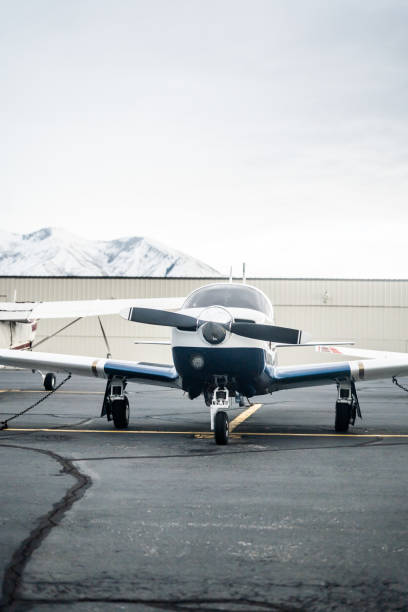 istock A small front propeller private airplane parked outdoors with a mountain backdrop and snow-capped peaks visible in the distance 2193202034