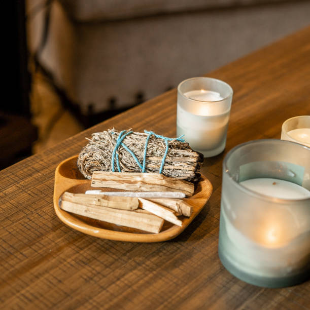 istock A sage bundle and palo santo displayed with lit candles on a rustic wooden table, creating a cozy and spiritual ambiance 2193202045