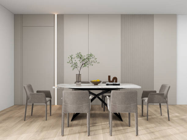 istock A modern dining room with minimalist decor featuring a marble table, gray upholstered chairs, a unique pendant light, and a vase with green branches. 2193202690