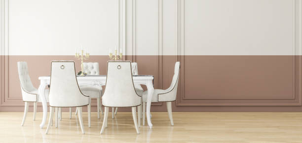 Luxury dining room decor mock-up, white table and chairs with gold accents, set against a classic two-tone wall with ornate moldings. 3d rendering.