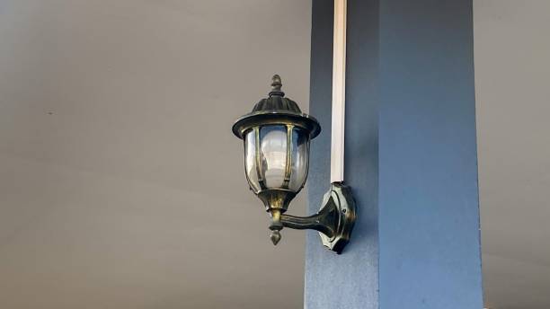 An old lamp attached to a house pole.
