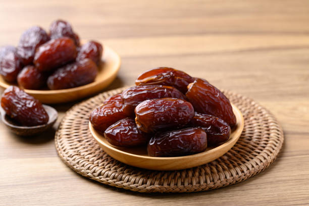istock Date palm fruit (MedJool) on wooden plate 2193204799