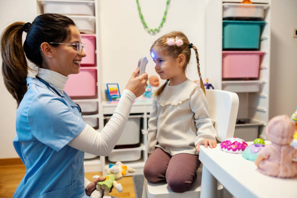 istock Pediatrician measuring temperature with thermometer on little cute patient's forehead at playroom. 2193206639