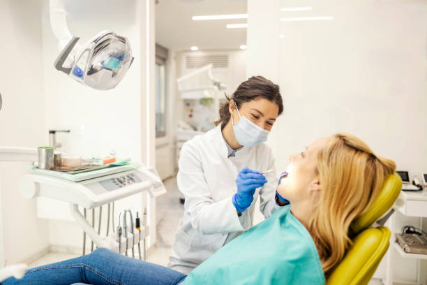 istock Professional dentist doing women's teeth checkup during the appointment at dentist office. 2193207073