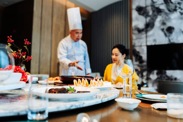 Asian senior chef introducing his new dish to the distinguished guest.