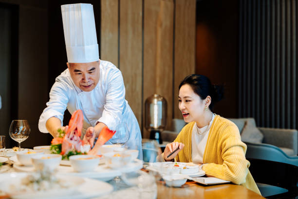 istock Asian senior chef introducing his new dish to the distinguished guest. 2193214286