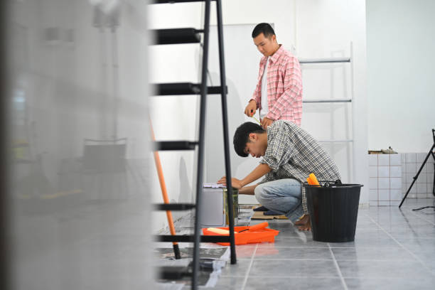 istock Two asian men painting a wall with a roller brush during a home renovation project 2193214456