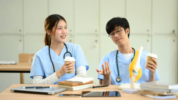 istock Two medical students in scrubs enjoying a coffee break while discussing their studies 2193214507