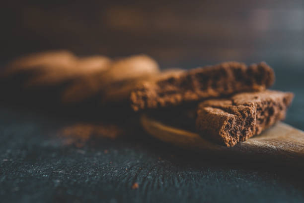 Chocolate brownie cookies on wooden spoon, sweets background.