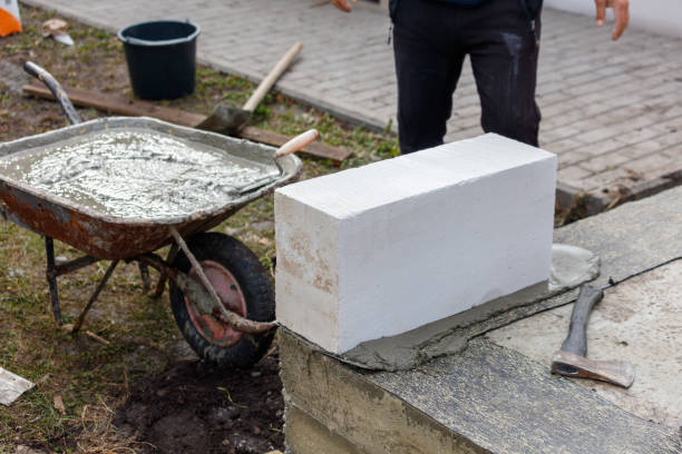 istock A man is working on a brick wall with a wheelbarrow and a hammer 2193217772