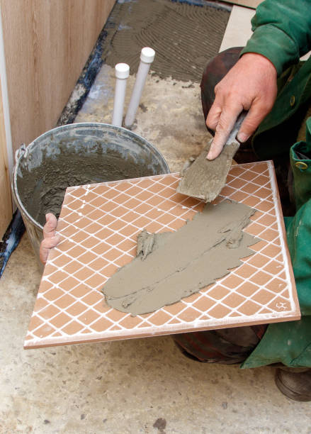 istock A man is laying tiles on a floor 2193217929