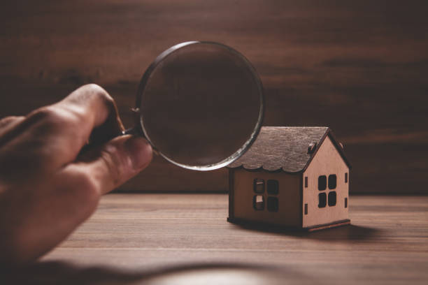 istock magnifying glass with wooden house model. 2193220447