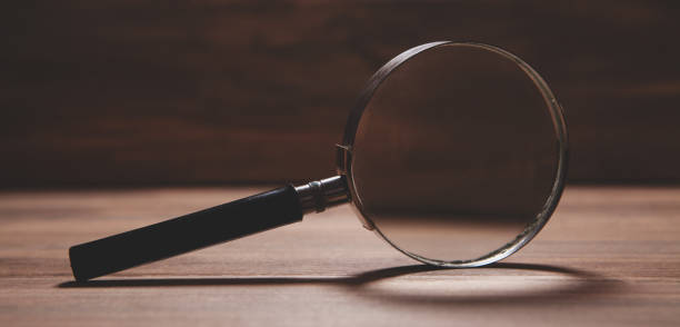 istock magnifying glass on wooden table background 2193220456