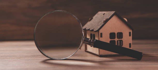 istock house model and magnifying glass on a table 2193220468